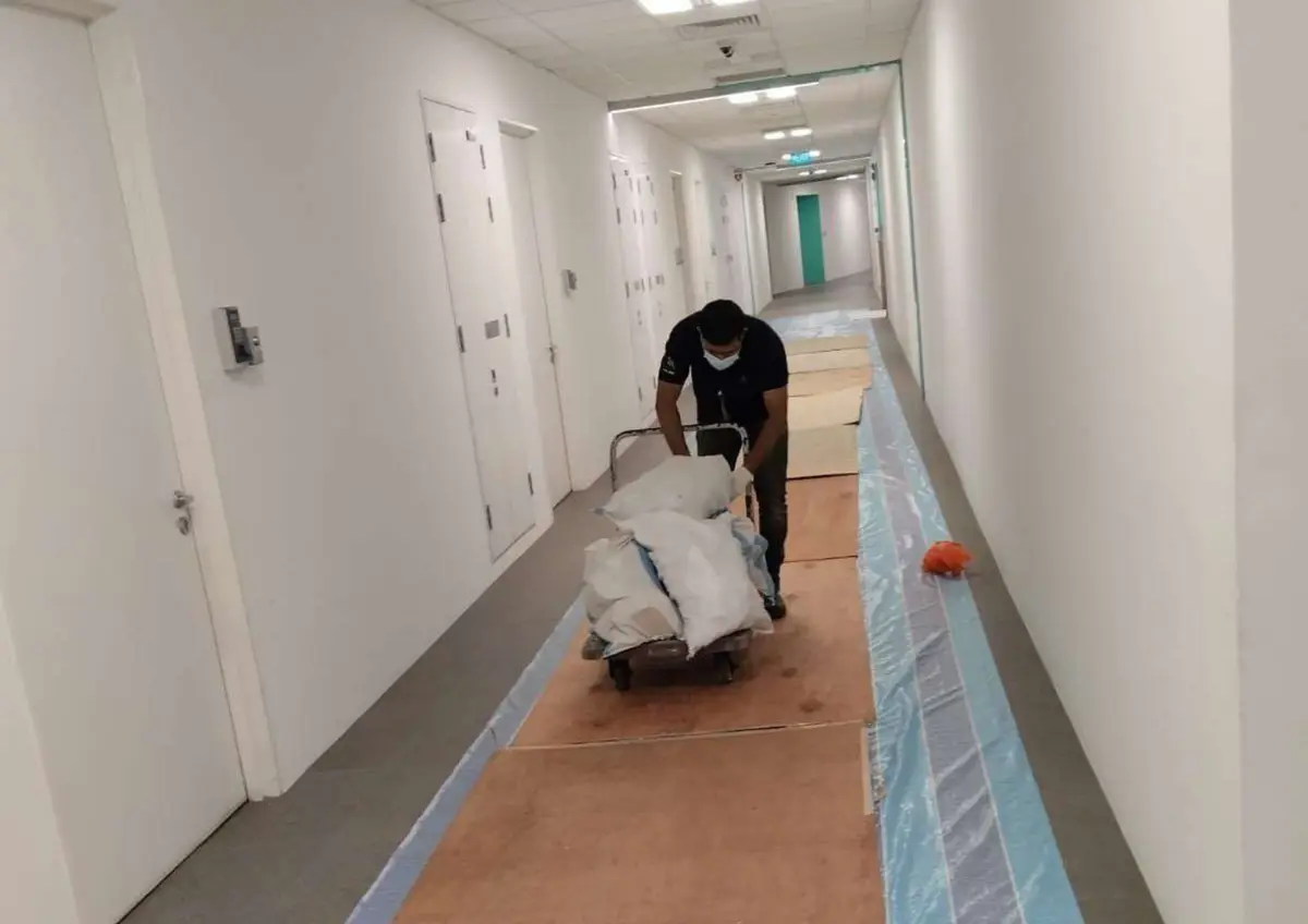 Contractor moving materials along a corridor